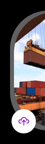 A crane lifting a red shipping container above stacked cargo containers at a busy shipping port, with a clear sky in the background.